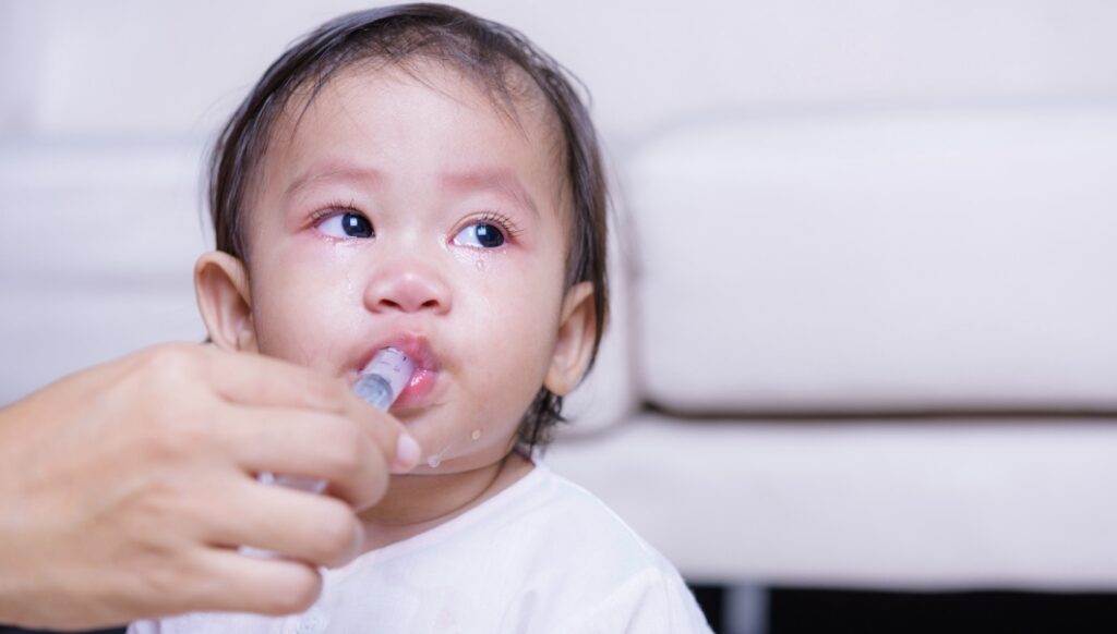 a baby being fed by a syringe